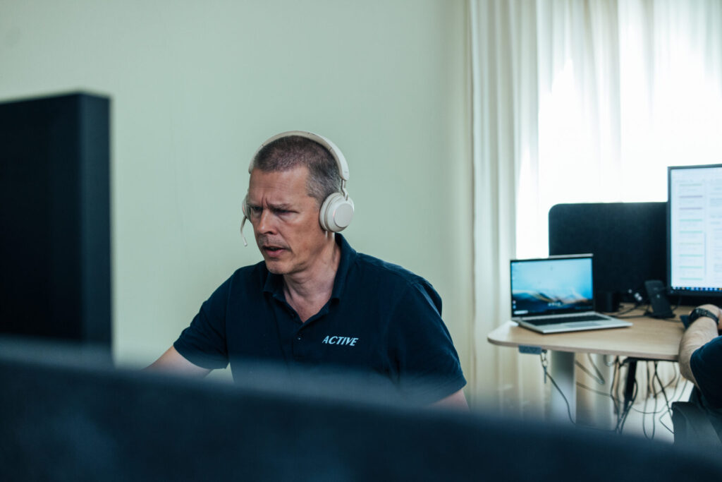 Active IT-tekniker med headset arbetar koncentrerat vid servicedesk